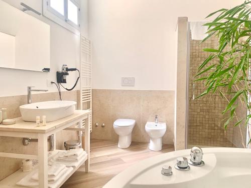La salle de bains est pourvue d'un lavabo, de toilettes et d'une baignoire. dans l'établissement Dimora San Biagio Suites&Apartment, à Lecce