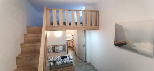 uma escada de madeira numa sala de estar com uma escada em New cosy studio em Karlovy Vary