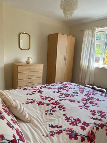 a bedroom with a bed with a floral bedspread at tabor lane Dolwar our little cottage in Criccieth