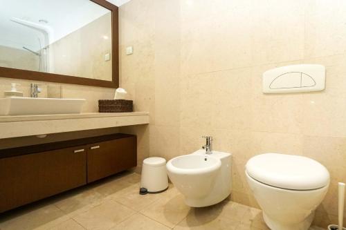 a bathroom with a toilet and a sink and a mirror at Lisbon Best Places - Rooftop in Lisbon