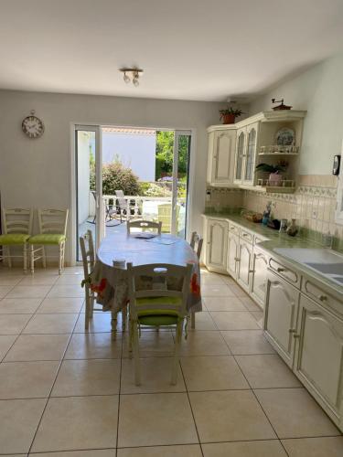 a kitchen with a table and chairs in it at Vendée - Maison de Vacances in La Genétouze