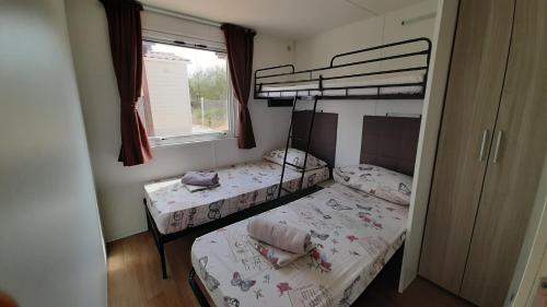 two bunk beds in a room with a window at Mobile homes Kamp Maslina, Biograd na Moru in Biograd na Moru