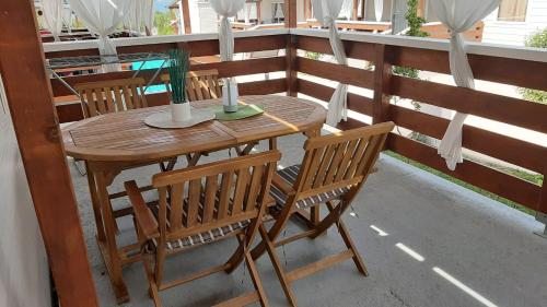 a wooden table and chairs on a balcony at Mobile homes Kamp Maslina, Biograd na Moru in Biograd na Moru