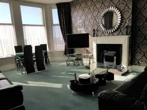 a living room with a fireplace and a tv at Promenade Apartments in Southport