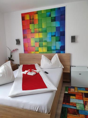 um quarto com uma cama com uma pintura colorida na parede em Casa Ana em Cluj-Napoca