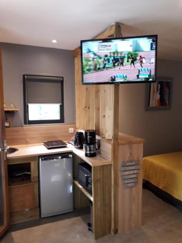 a kitchen with a television and a refrigerator at Le Pigeonnier in Brive-la-Gaillarde
