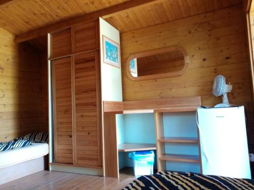 a cabin with a bed and a refrigerator in a room at Penzion Slunce nad Vinným Sklepem in Moravská Nová Ves