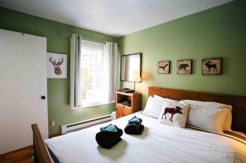 a bedroom with a large bed with green walls at The MountainSide by Escapades Tremblant in Mont-Tremblant