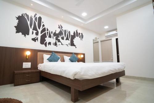una camera con un grande letto e una parete con alberi di Hotel Silver Oak ad Aurangabad
