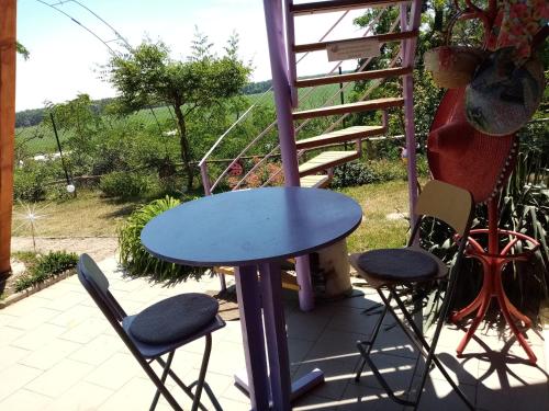 a blue table and two chairs on a patio at Penzion Slunce nad Vinným Sklepem in Moravská Nová Ves