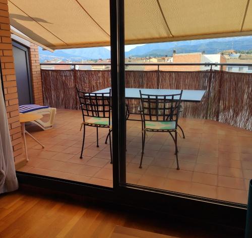 a patio with a table and chairs on a balcony at ACOGEDOR ÁTICO DÚPLEX EN TREMP in Tremp