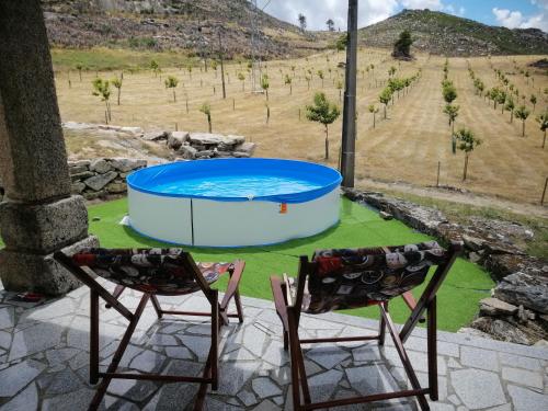 two chairs sitting on a patio with a pool at Quinta do Chãozinho in Alijó