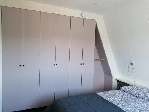 een slaapkamer met witte kasten en een bed bij 4T4 Apartment B in Egmond aan den Hoef