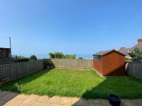 ein Hinterhof mit einem Hof mit Zaun und einem kleinen Schuppen in der Unterkunft Horizon Vista in Ilfracombe