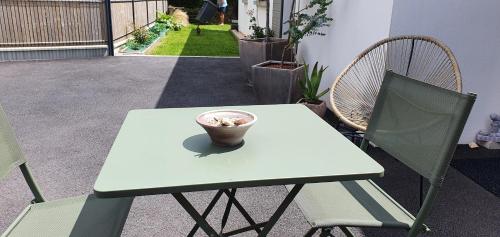 a white table with a cup on it on a patio at Chambre de la mer blanche in Bénodet