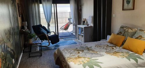 a bedroom with a bed and a view of a balcony at Chambre de la mer blanche in Bénodet