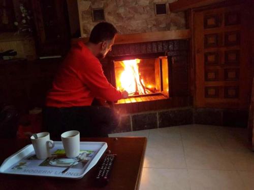 a man sitting in front of a fireplace at VikerBIESCAS in Biescas