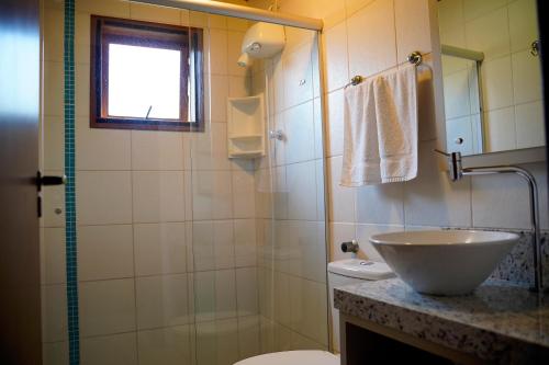 a bathroom with a sink and a toilet and a shower at Morada dos Prass in Guarda do Embaú