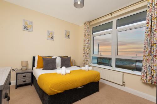 a bedroom with a yellow bed and a window at Large 2 Bedroom Apartment in Ashford with PARKING in Ashford