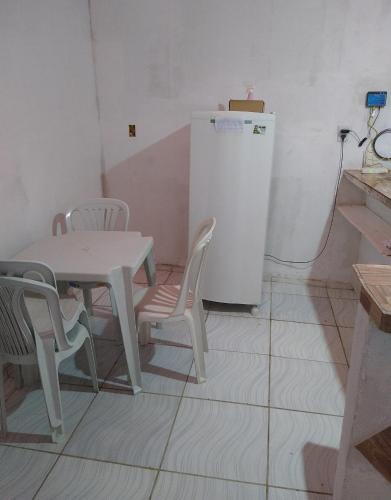 a table and chairs and a refrigerator in a room at Casa inteira frente p rio in Luis Correia