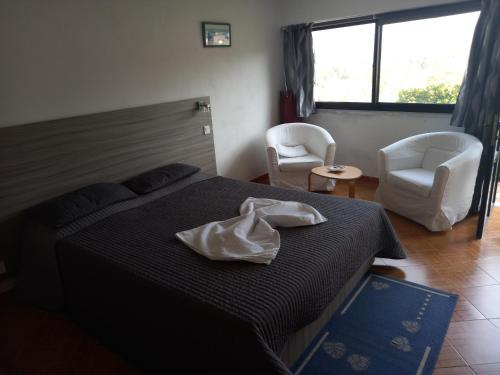 a bedroom with a bed and two chairs and a window at Ritual Greece Appartement 2 in Kypséli