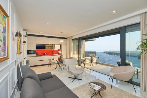 a living room with a couch and chairs and a kitchen at New & Luxury 5* with Breathtaking View- Kiki Lu Apartment in Dubrovnik