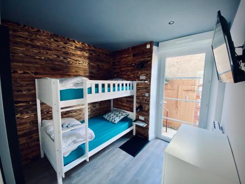 - une chambre avec des lits superposés et un mur en bois dans l'établissement Gîte « Au bord des Embruns », à Grandcamp-Maisy