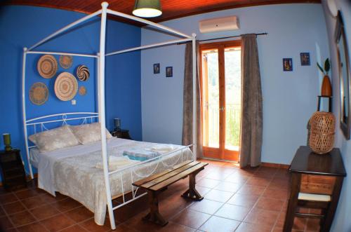 a bedroom with a canopy bed and a wooden bench at Ithaki House in Vathi