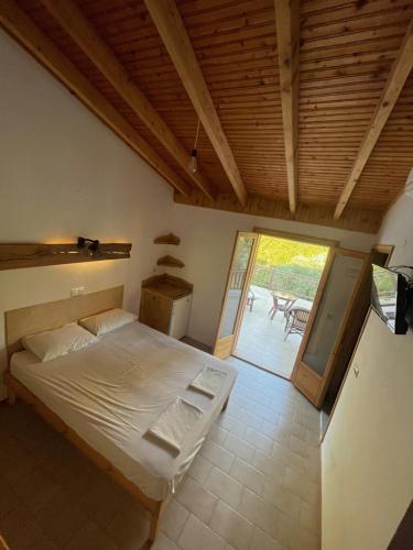a bedroom with a large bed and a patio at Pension Oasis in Votsi
