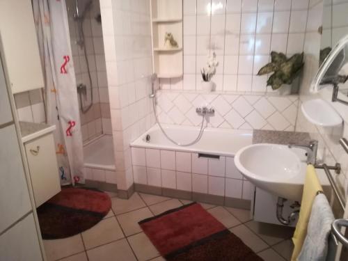 a bathroom with a tub and a sink and a bath tub at schnuggliche Ferienwohnung in Eppendorf