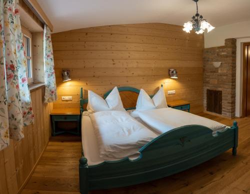 a bedroom with a green bed with white sheets and pillows at Frühstückspension Haus Mayr in Hinterstoder