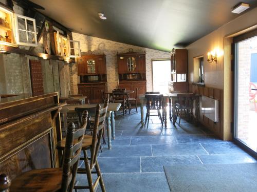 a restaurant with wooden tables and chairs in a room at Hoeve Chartreuse in Bruges