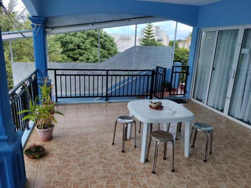 a white table and four stools on a balcony at Bob Apartments in Calodyne