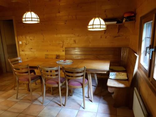 - une salle à manger avec une table et des chaises en bois dans l'établissement Appartement - dans le chalet Carmazin, à Morgins