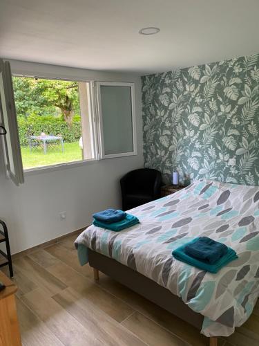 a bedroom with a bed with blue towels on it at L'entre 2 Lyon Grenoble - Villa avec Jacuzzi in Izeaux