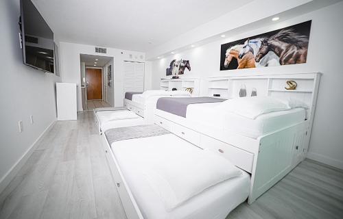 Habitación blanca con 2 camas y TV de pantalla plana. en Modern and Luxurious Brickell Studio en Miami