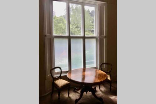 a table and chairs in front of a window at Entire Maisonette Torquay Newly Renovated in Torquay