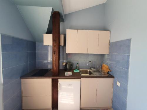 a small kitchen with white cabinets and a sink at Avanta in Liepāja
