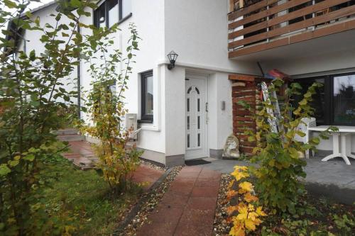 a white door of a house with a cat sitting outside at Bergblick in Medebach
