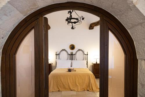 Un arco que conduce a un dormitorio con cama en Masseria Pilano, en Crispiano