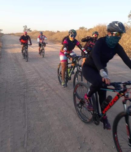 a group of people riding bikes down a dirt road at Cuatro Estaciones in General Rodríguez