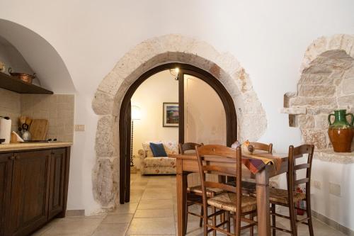 una cucina e una sala da pranzo con tavolo e arco di Masseria Pilano a Crispiano