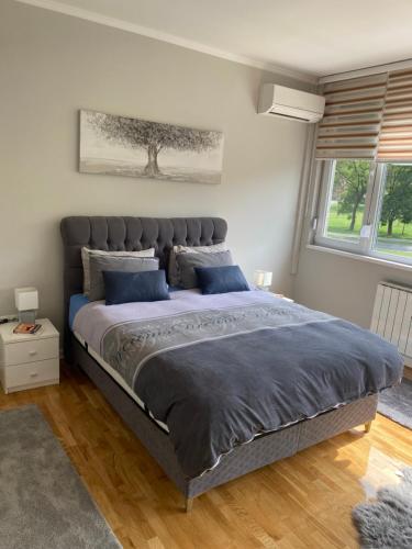 a bedroom with a large bed with blue pillows at Apartman "Amy Delux" in Zenica