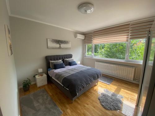 a bedroom with a bed and a large window at Apartman "Amy Delux" in Zenica