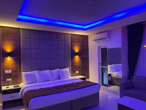 a bedroom with a large bed with a blue lighting at Presken Hotels @ Victoria Island in Apese