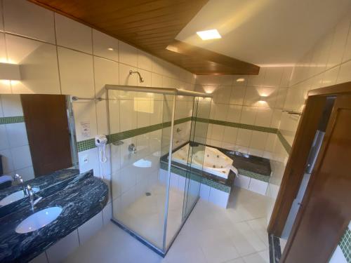 a bathroom with a glass shower and a sink at Pousada Porto da Barra in Barra Grande