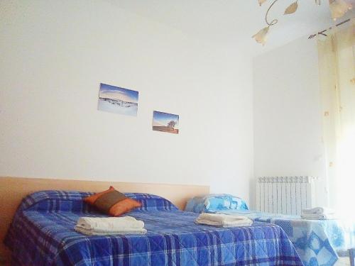 a bedroom with two twin beds with blue sheets at B&B Casa Valentina a Linguaglossa in Linguaglossa
