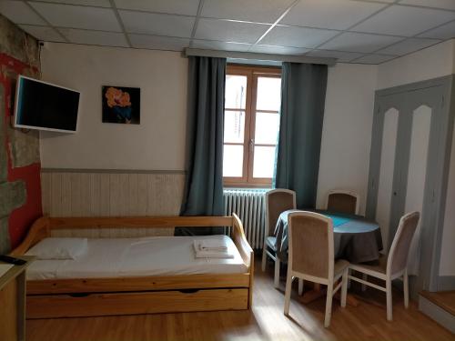 a bedroom with a bed and a table and a window at Hotel de Savoie in Annecy