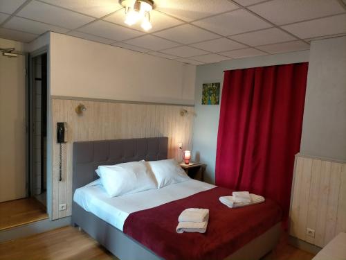 a bedroom with a bed with two towels on it at Hotel de Savoie in Annecy
