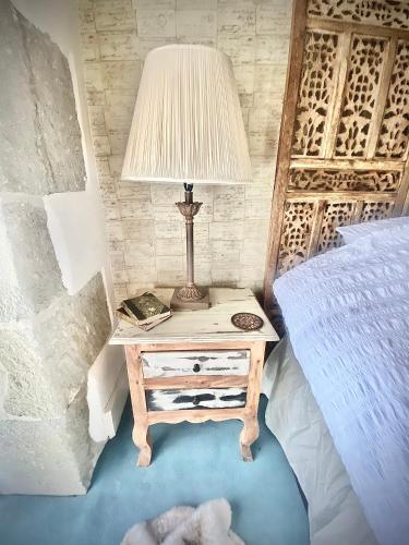 a table with a lamp on it next to a bed at Luxurious, Fabulous, Fun, Contemporary Suite in Retreat Centre in Salisbury